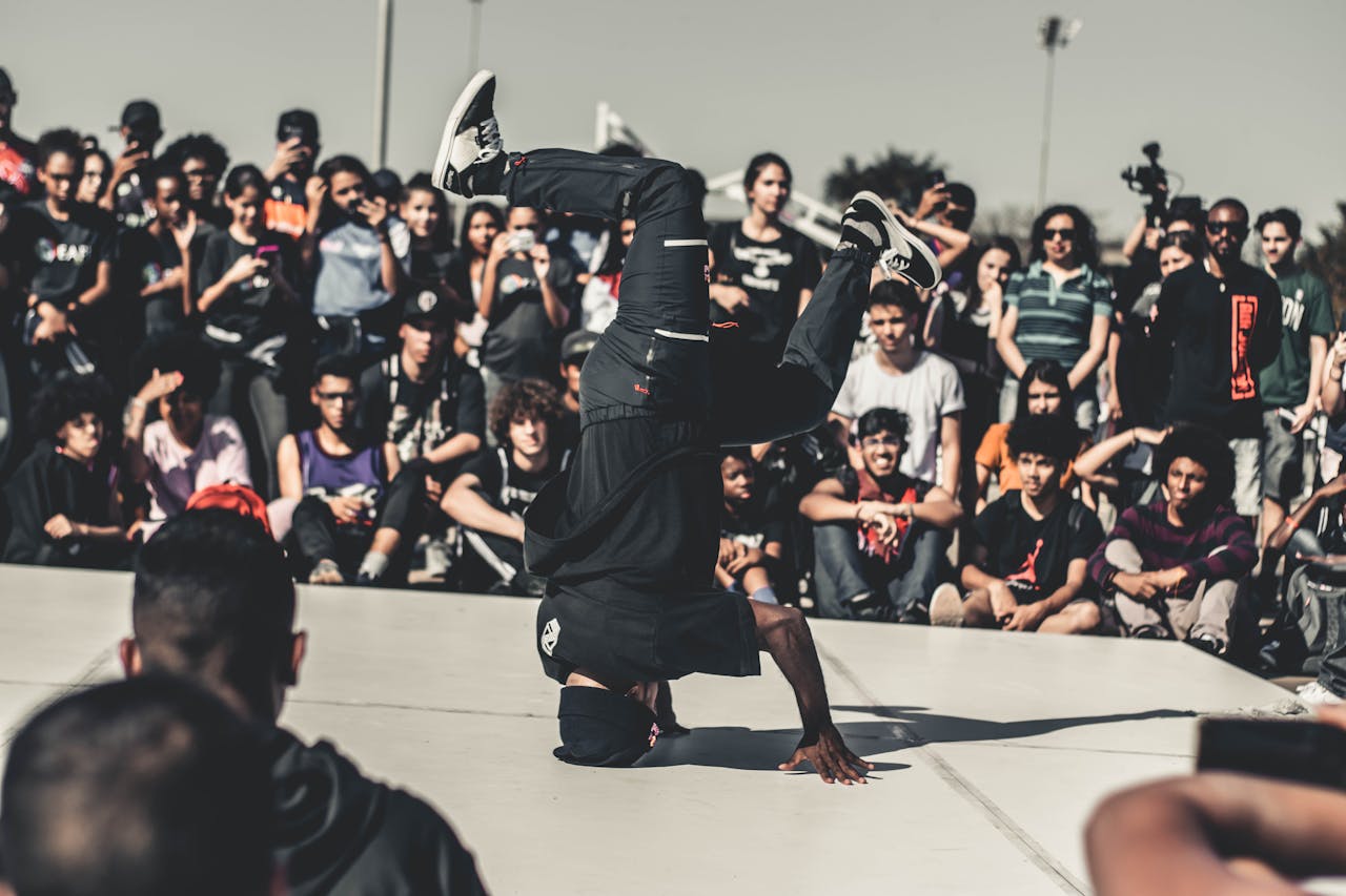 Outdoor breakdance event with diverse crowd enjoying a lively street performance.